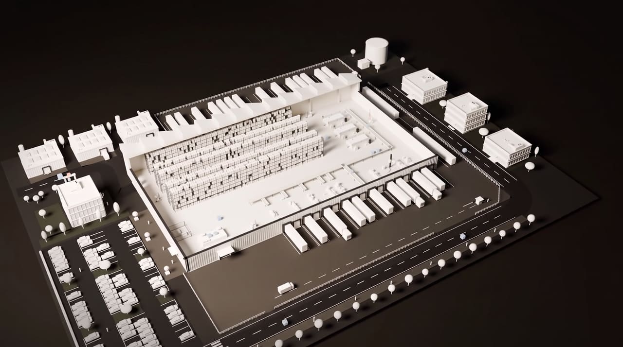 A white miniature of a distribution centre with loading docks, trucks and nearby offices, from the Instract film.