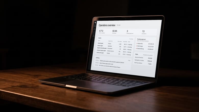A laptop on a walnut desk showing the Nordfeld Group operations overview in the Instract AI OS